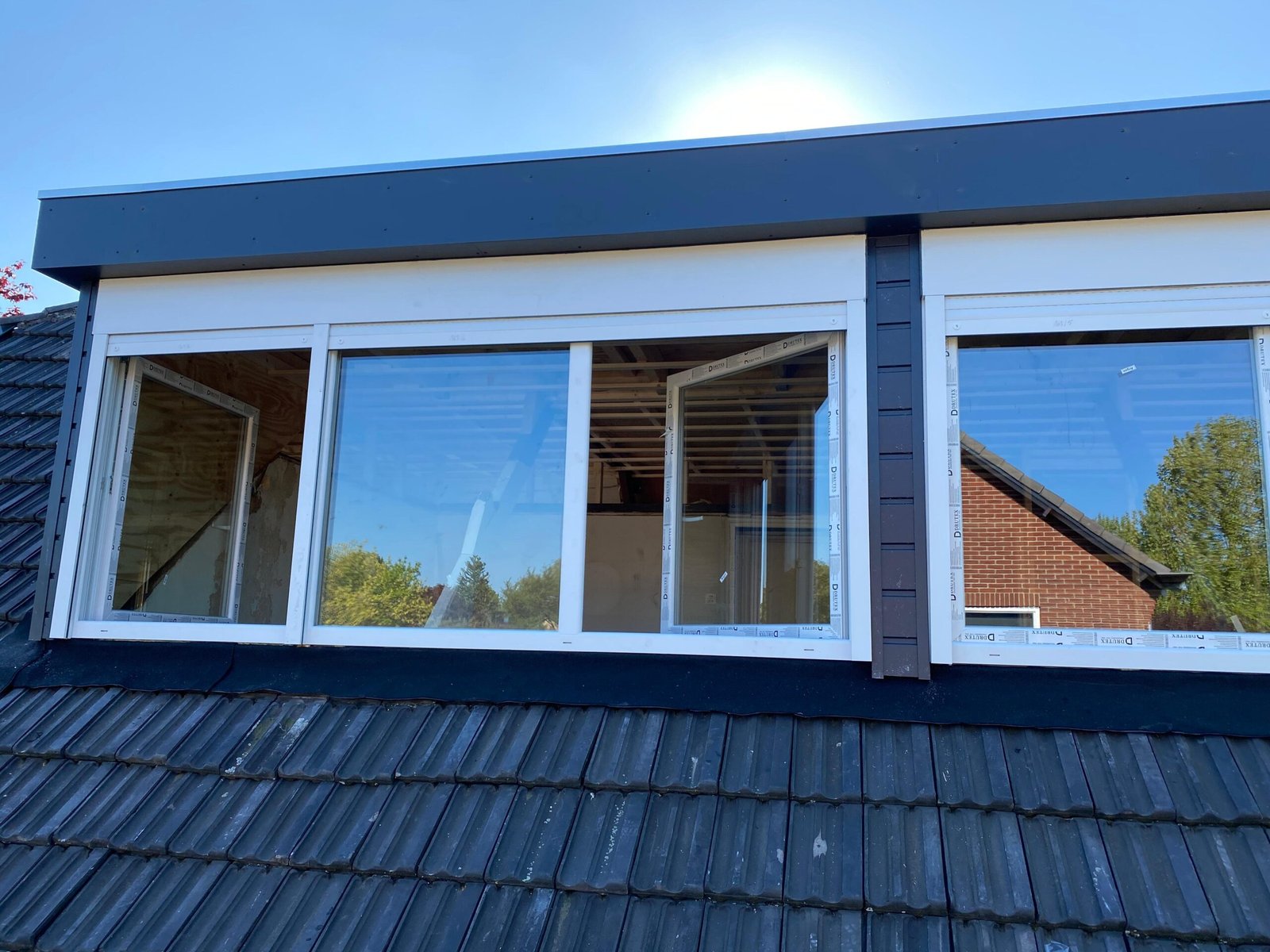 Dakkapel met grote glasvlakken en witte kunststof kozijnen